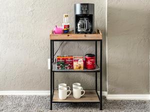 a shelf with coffee cups and a coffee maker at Town House in Norman