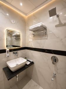 a white bathroom with a sink and a mirror at Hotel KS Palace in Varanasi