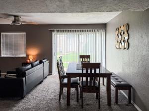 a dining room with a table and chairs and a couch at Town House in Norman
