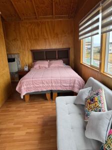 a bedroom with a bed and a couch at Depto huerto 23 in Puerto Natales