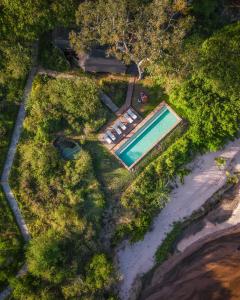 an overhead view of a swimming pool next to a beach at Elewana Sand River Mara in Talek