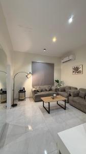 a living room with a couch and a coffee table at أجنحة السمو in Hail