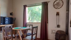 a table and chairs in a room with a window at Vivir en Maimará in Maimará