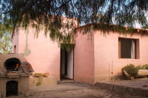 a pink building with a pizza oven in front of it at Vivir en Maimará in Maimará