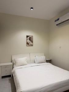 a bedroom with a large white bed with white sheets at أجنحة السمو in Hail