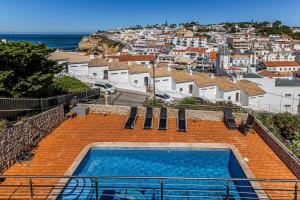 a swimming pool on top of a building with a city at Villa Sea View Carvoeiro in Carvoeiro