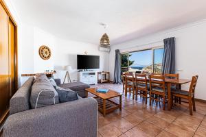 a living room with a couch and a table and chairs at Villa Sea View Carvoeiro in Carvoeiro