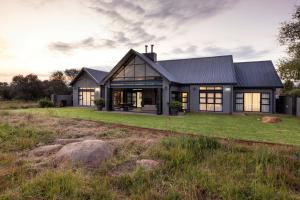 a house with a black roof at Sasavona Cottage - 349 Vaal de Grace Golf Estate in Parys