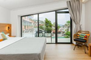a bedroom with a bed and a large glass window at Petra Suites Tolo in Tolo +47 photos