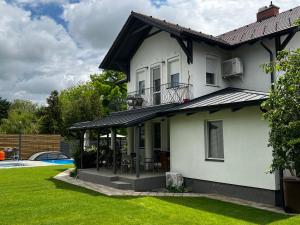 a white house with a gazebo next to a yard at Best Apartman Lelle 2 in Balatonlelle