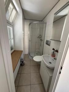 a small bathroom with a sink and a shower at Haus zur Eiche Private 1 Zimmerstudios in Chur +31 photos