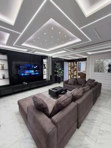 a large living room with couches and a tv at De Lexury Homes in Otinshi
