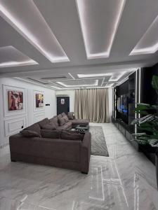 a living room with a couch and a television at De Lexury Homes in Otinshi +8 photos
