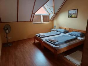 a bedroom with two beds and a window at Basti Apartman in Gyenesdiás
