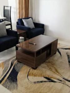 a living room with a coffee table and two chairs at Modern Family Home in Ikoyi in Lagos