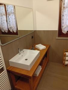 ein Badezimmer mit einem weißen Waschbecken und einem Spiegel in der Unterkunft Agriturismo I Grappoli in Serralunga d'Alba + 63 Fotos
