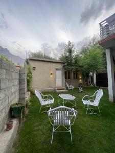 a group of chairs and a table in a yard at Alpen Hotel Skardu in Skardu