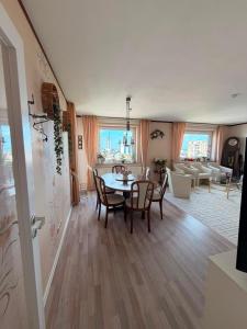 a dining room and living room with a table and chairs at Deichherz - Skyline & Wohlfühlatmosphäre inklusive Parkausnahmegenehmigungsschein in Bremerhaven