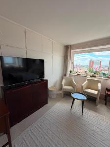 a living room with a large flat screen tv at Deichherz - Skyline & Wohlfühlatmosphäre inklusive Parkausnahmegenehmigungsschein in Bremerhaven