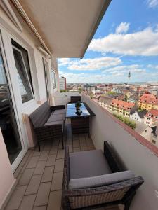 a balcony with a table and chairs and a view at Deichherz - Skyline & Wohlfühlatmosphäre inklusive Parkausnahmegenehmigungsschein in Bremerhaven