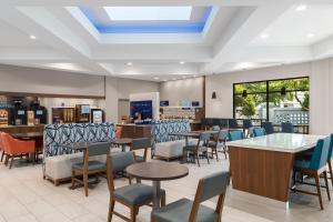 a dining room with tables and chairs and a cafeteria at Holiday Inn Express & Suites Memphis East by IHG in Memphis