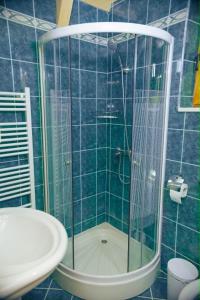 a blue tiled bathroom with a shower and a sink at Vikendica Hills Vlašić in Šišava +18 photos