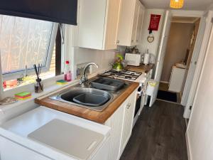 a small kitchen with a sink and a stove at The Lookout in Leysdown-on-Sea