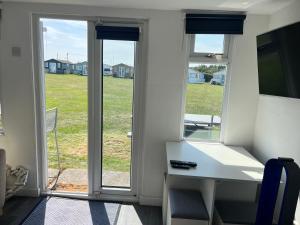 a room with a desk and a view of a yard at The Lookout in Leysdown-on-Sea