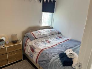 a small bedroom with a bed and a dresser at The Lookout in Leysdown-on-Sea