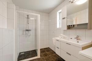 a white bathroom with a shower and a sink at Dorpsplein 42 in Callantsoog +29 photos