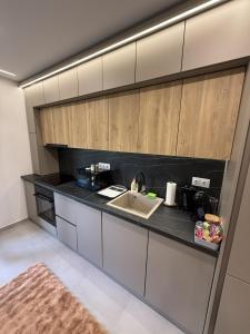 a kitchen with a sink and a counter top at ViA Lux Apartman in Pécs