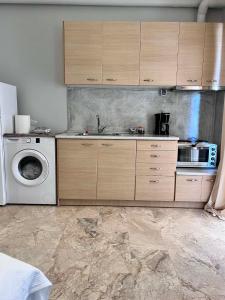 a kitchen with a sink and a washing machine at Studios Μιχαλαρεα in Kyparissia +3 photos