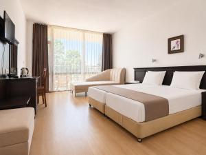 a hotel room with a large bed and a couch at Hotel Jupiter in Sunny Beach