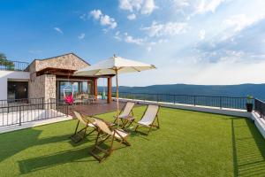 a patio with lawn chairs and an umbrella on a roof at Villa Verdura in Budva
