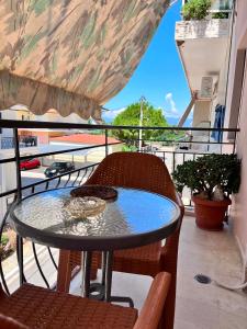 a glass table and chairs on a balcony at Studios Μιχαλαρεα in Kyparissia