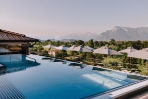 ein Pool in einem Resort mit Sonnenschirmen in der Unterkunft Genussdorf Gmachl - Hotel & Spa in Bergheim