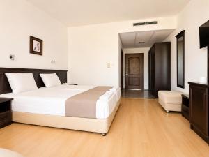 a bedroom with a large white bed and a chair at Hotel Jupiter in Sunny Beach +21 photos
