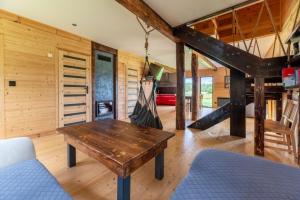 a wooden room with a wooden table and a staircase at Leśny Wyraj in Borsuki