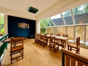 a dining room with wooden tables and chairs and windows at Golden Fleece Hotel in Ureki