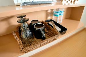 a shelf with a tray with cups and utensils at RAC's Inn Malumpati in Pandan +55 photos