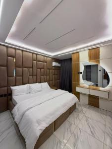 a bedroom with a large bed and a tv at De Lexury Homes in Otinshi
