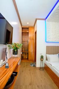 a living room with a bed and a tv at RAC's Inn Malumpati in Pandan