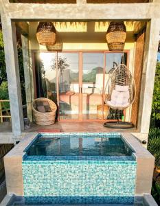 a swimming pool with a chair and a swing at VISTA Cadlao in El Nido Airport