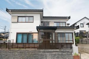 a white house with stairs in front of it at Kaga Travel - Hakusandai, Whole building for rent in Kaga