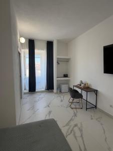 a room with a bedroom with a table and a chair at Alexandra Rooms & Suitess in Sassari