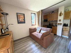 a living room with a couch and a kitchen at Le cocon dans les nuages in Lélex +11 photos