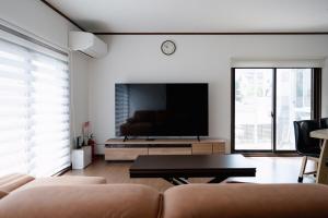 a living room with a couch and a flat screen tv at Kaga Travel - Hakusandai, Whole building for rent in Kaga