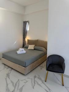 a bedroom with a bed and a chair at Alexandra Rooms & Suitess in Sassari