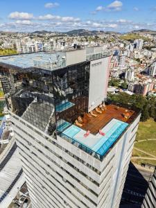a building with a swimming pool on top of it at Trade Hotel in Juiz de Fora
