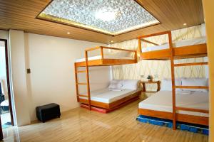 a bedroom with two bunk beds and a skylight at RAC's Inn Malumpati in Pandan
